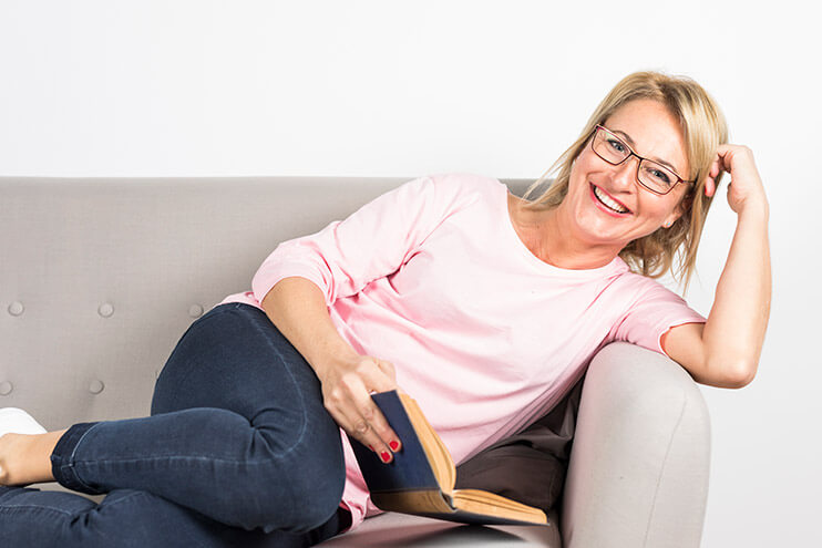 Middle age woman happy on the couch after vaginal rejuvenation